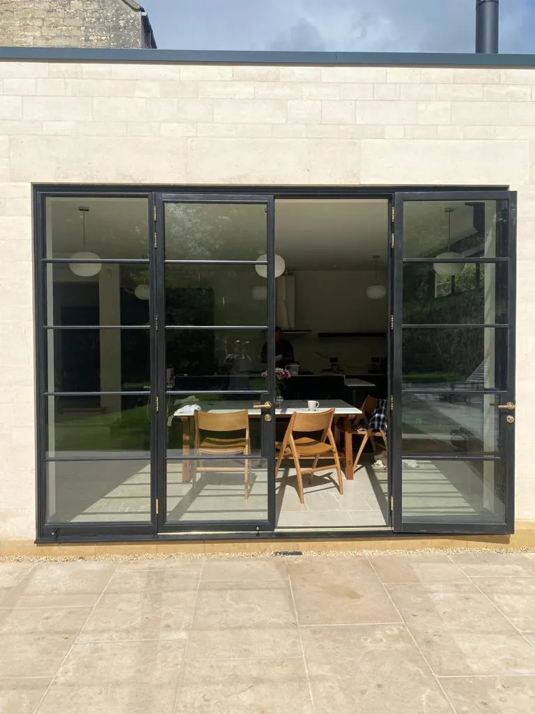Dark steel-look casement and glazed door to the contemporary extension seen from the terrace