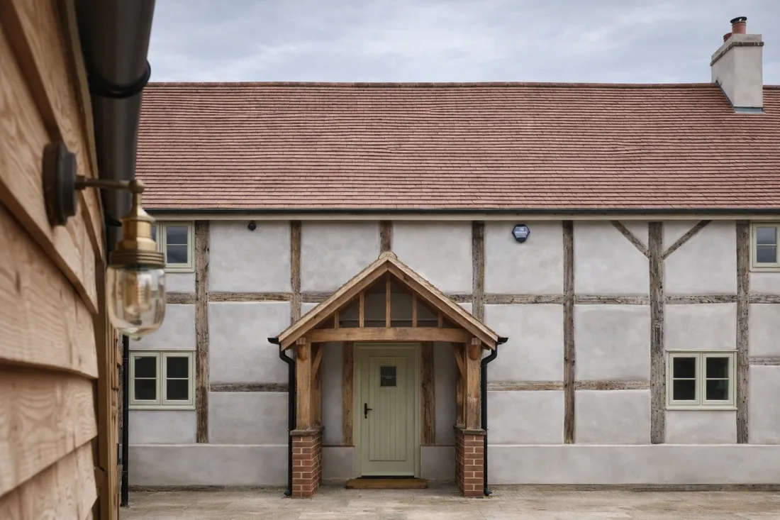 A period property with traditional timber windows and a panelled door, in soft daylight