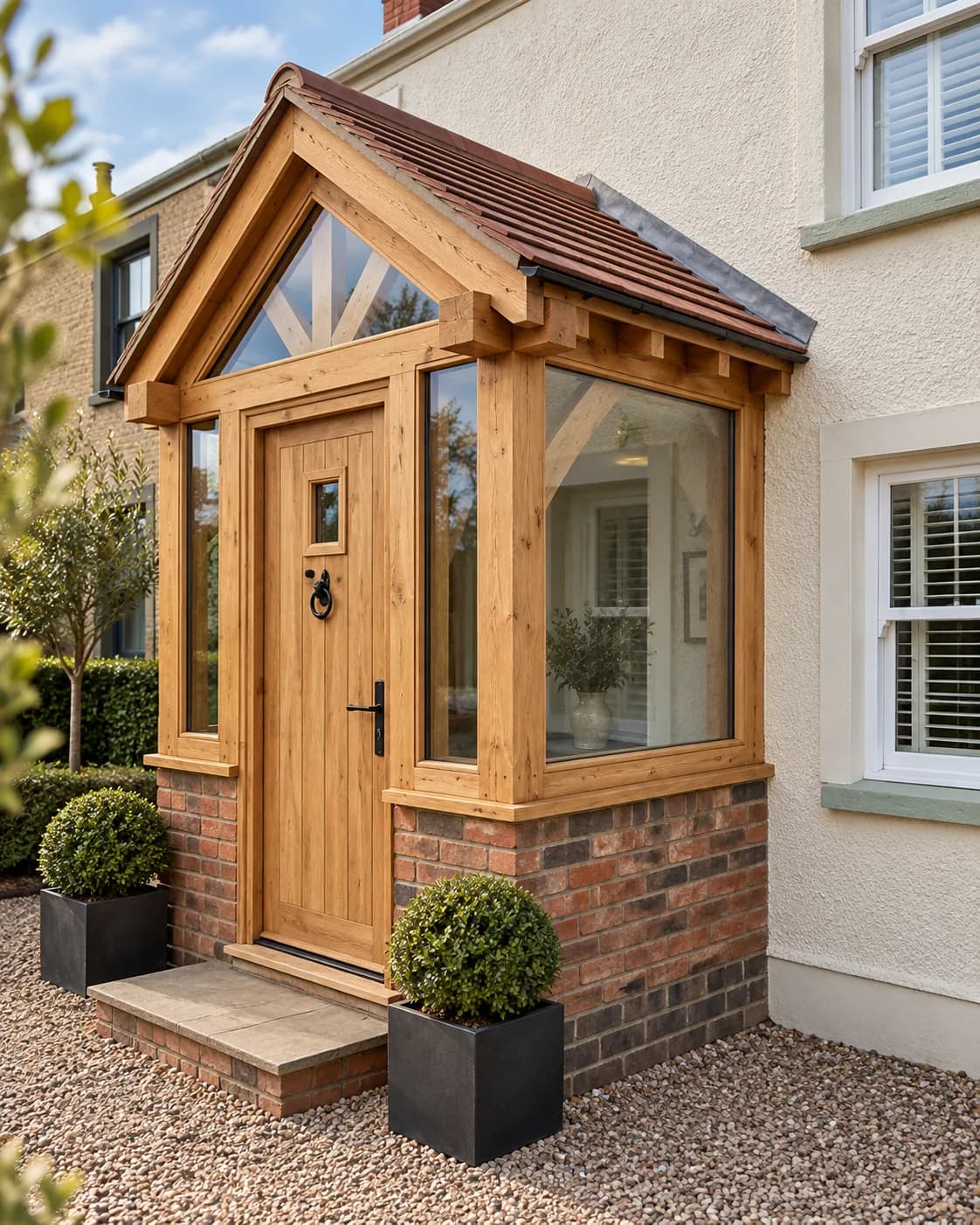 Oak-framed porch with glazed sides and an oak entrance door on a rendered house