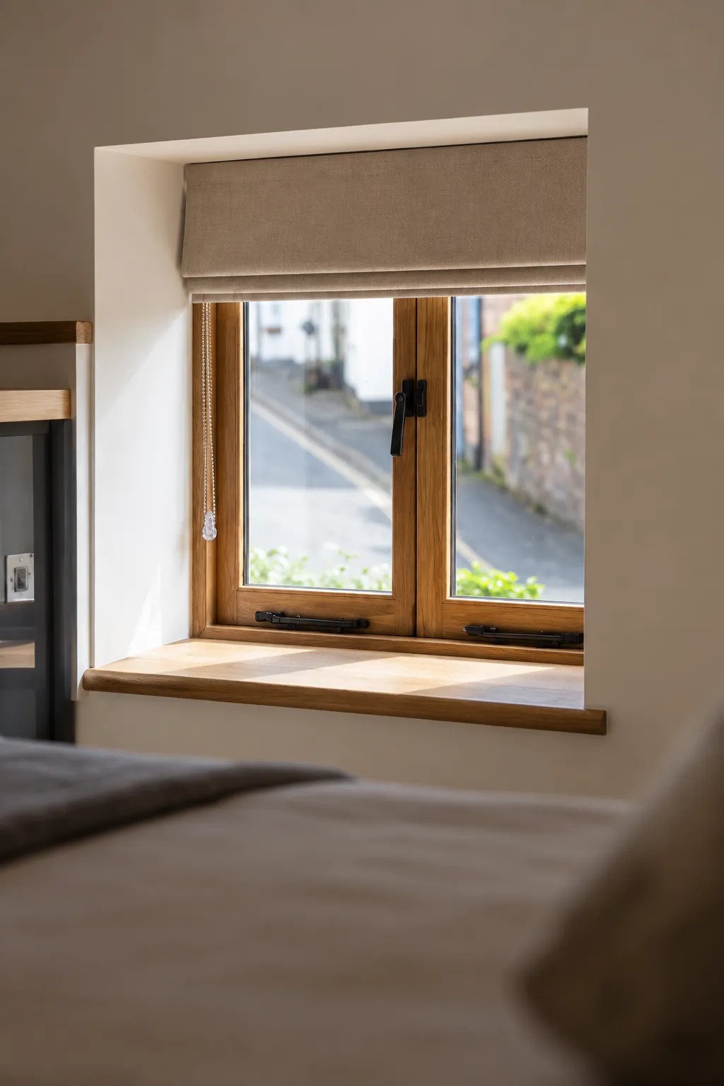 Oak casement window seen from a bedroom, set deep in the wall above an oak window board